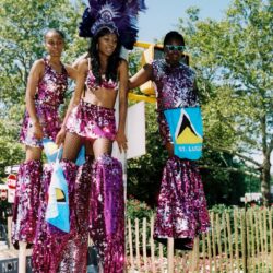 Three stilt performers in purple carnival costumes