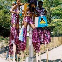 Stilt walkers in purple sequined carnival costumes
