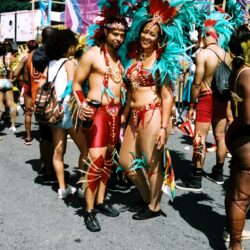 Two carnival dancers in teal feathered costumes