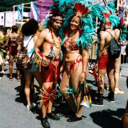 Two performers in red and teal carnival costumes