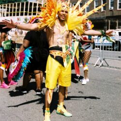 Person in yellow carnival costume with feathers