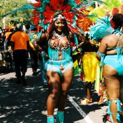 Carnival dancer in vibrant red and turquoise feathers