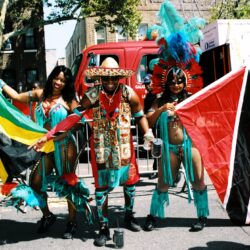 Three carnival dancers holding colorful flags