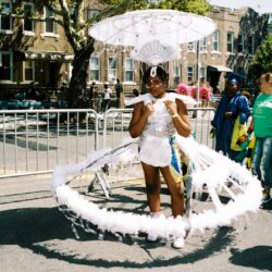 Performer in white hoop-skirted parasol costume