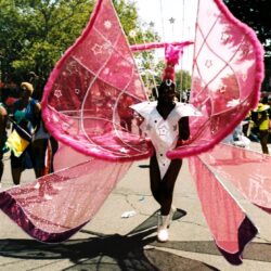 Parade performer in giant pink butterfly wings