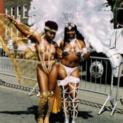 Two carnival performers in white feathered costumes