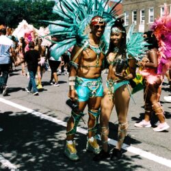 Two performers in turquoise feathered carnival costumes