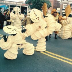 Street parade performers in cream spiral costumes