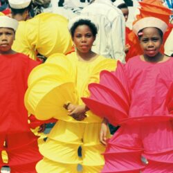 Children in red, yellow, pink parade costumes