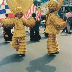 Two performers in gold ruffled parade costumes