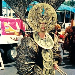 Parade performer wearing ornate gold sun costume