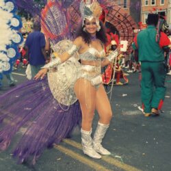 Woman in silver carnival costume with purple feathers