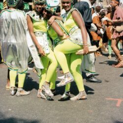 Three performers in neon green carnival costumes