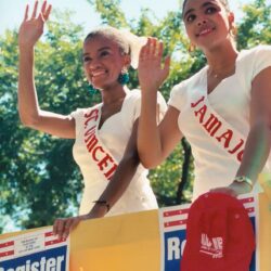 Two women wearing sashes on voter registration float