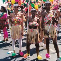 Three carnival dancers in colorful floral costumes