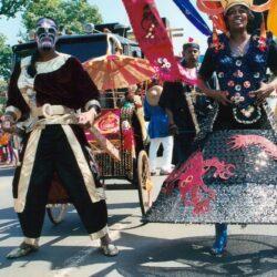 Painted face performers in elaborate parade costumes