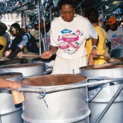 Woman playing steel drums in street band