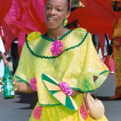 Carnival participant in yellow costume with flowers
