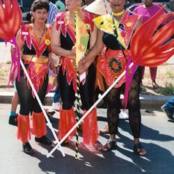 Group in bright carnival costumes holding flame props