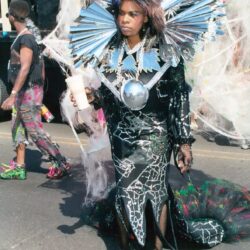 Person in elaborate metallic collar parade costume