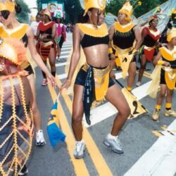 Women in yellow carnival costumes dancing in parade
