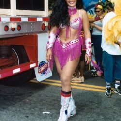 Woman in pink beaded carnival costume and sunglasses