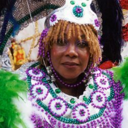 Person in purple and green Mardi Gras costume