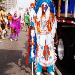 Colorful person in feathered headdress at parade