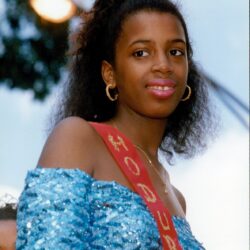 Smiling young woman in blue dress with sash