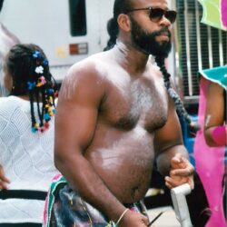 Shirtless man with braided beard at parade