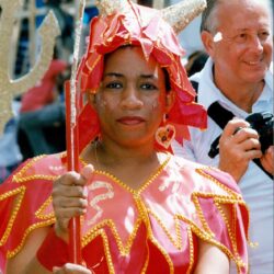 Woman in red carnival costume holding trident