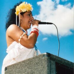 Woman singing into microphone wearing flower crown