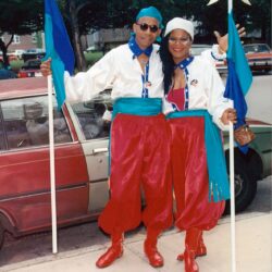 Two people in matching red-and-blue parade costumes