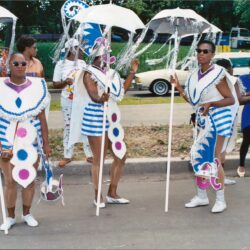 Three performers in blue-and-white carnival costumes