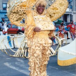 Person in golden ruffled costume with oversized hat