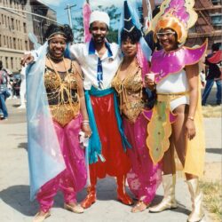 Four people wearing colorful carnival costumes