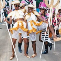 Three carnival performers in gold-white costumes
