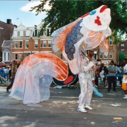 Person in large colorful fish costume at parade