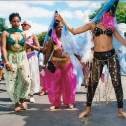 People in colorful carnival costumes dancing in street