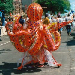 Person in large orange octopus costume at parade