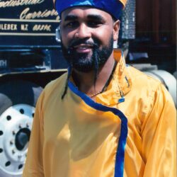 Smiling person in yellow and blue traditional attire