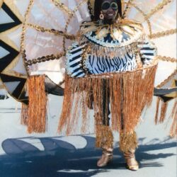 Person in elaborate gold carnival costume with headdress