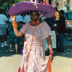Woman wearing oversized purple hat and dress