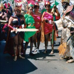 Parade performers in colorful feathered costumes