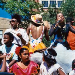 Colorful parade performers singing on float