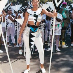 Woman in black-and-white carnival costume holding poles