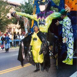 Colorful bat-themed parade float with performers
