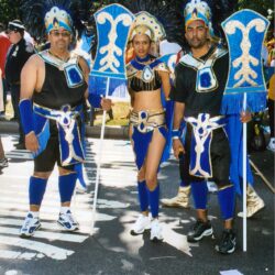 Three performers in blue and gold carnival costumes