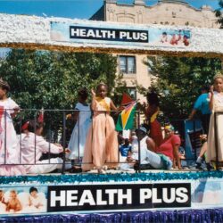 Health Plus parade float with women and flags