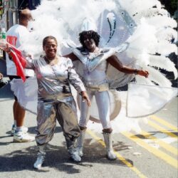 Two carnival performers in silver and white costumes